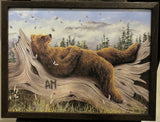 AM 2 oil by Robert Bissell features a bear taking a nap on a log.